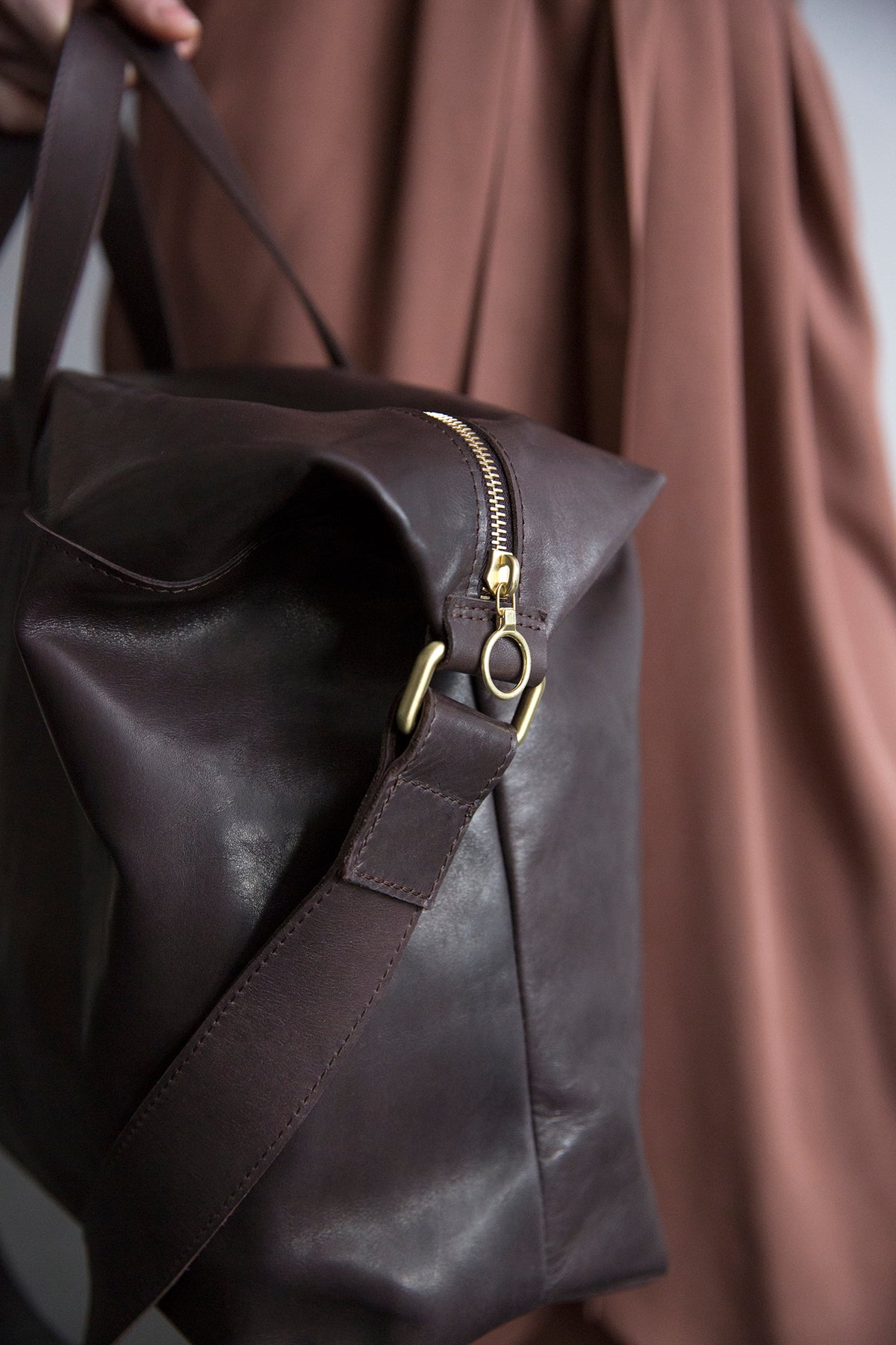 Top handles and shoulder strap, clean hardware detail.